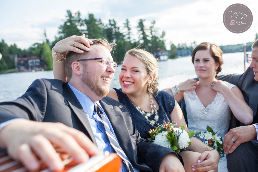 The wedding party takes a hacker craft boat ride on Lake Placid. Mabyn Ludke Photography