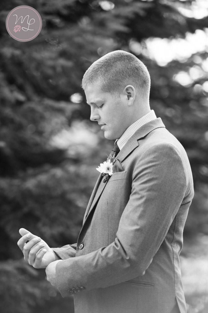 A groom straightens his cufflinks while waiting to see his bride for the first time in Lake Placid at the White Face Lodge. Mabyn Ludke Photography