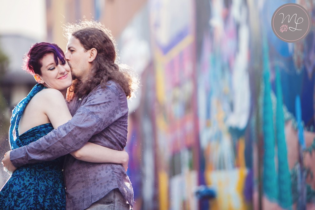 A fun couple hugs in Clarion Alley in San Francisco, CA. Mabyn Ludke Photography