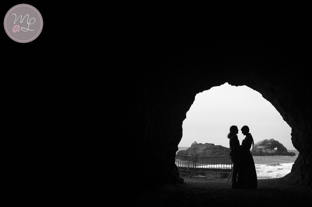A black and white of a couple in a cave at Lands End in San Francisco. Mabyn Ludke Photography
