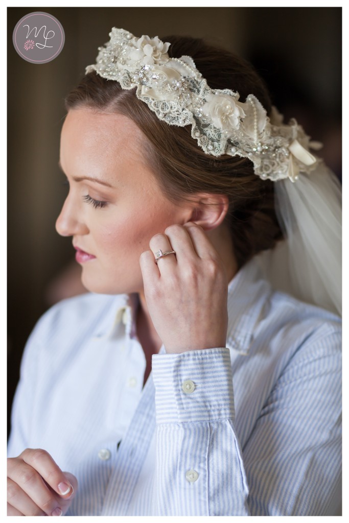 Bride slips on her lace headpiece and veil for her wedding at Sarah P. Duke Gardens. © Mabyn Ludke Photography