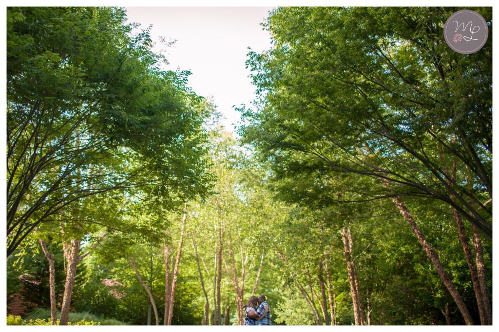 Bethany and Corey's share sweet kisses beneath the trees at their Greensboro engagement session.