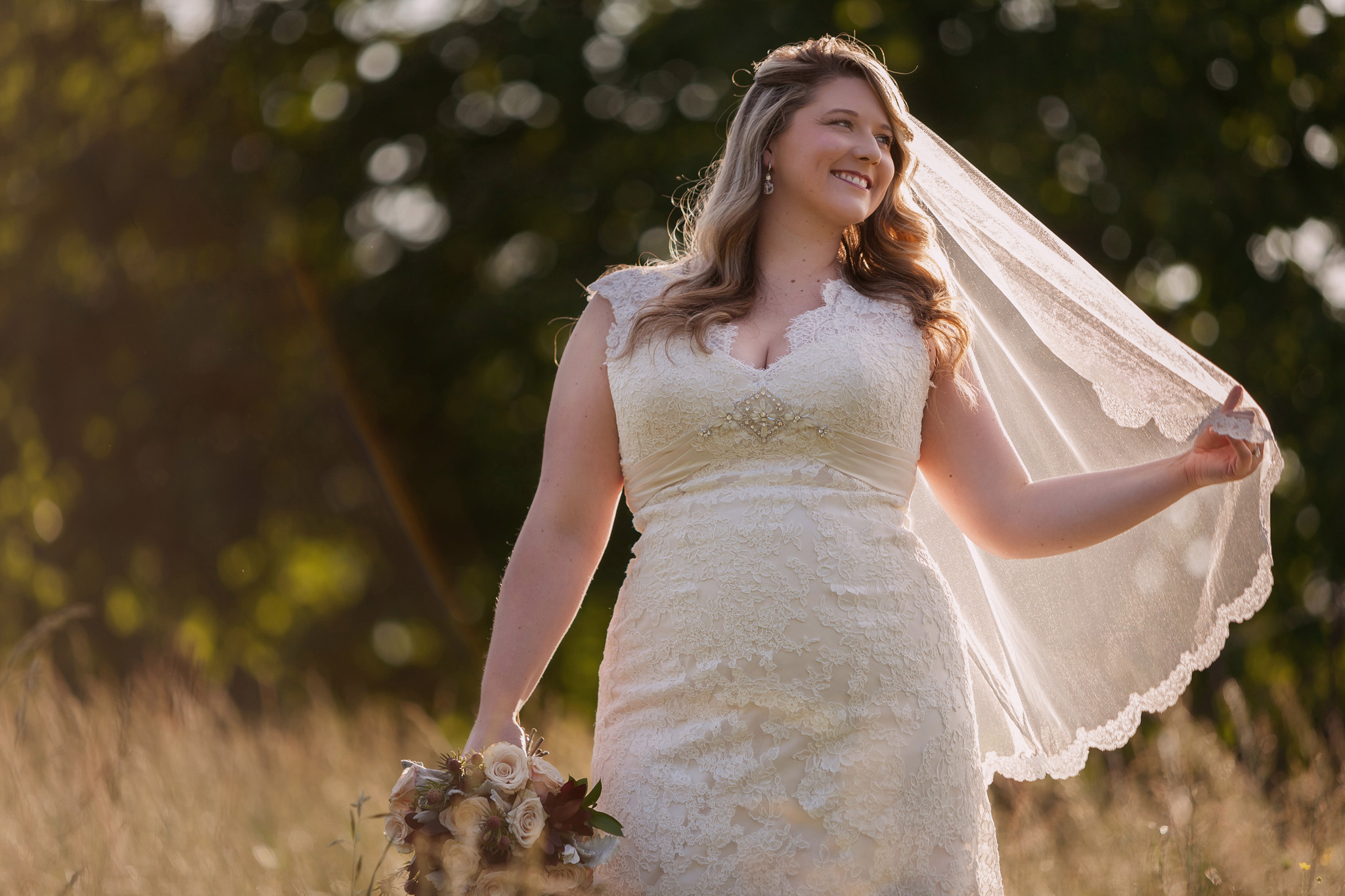 A sun kissed bride looks happily on during her bridal portrait session in Asheboro, NC Credit Mabyn Ludke Photography
