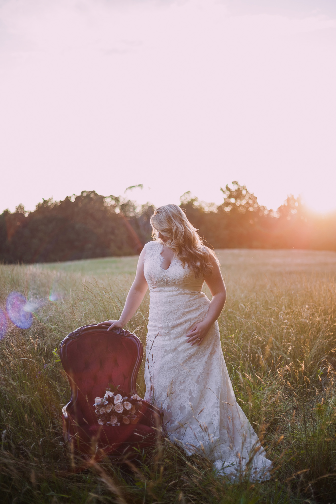 A red velvet chair is the perfect prop for this lovely bride at her Asheboro North Carolina bridal portrait session by Mabyn Ludke