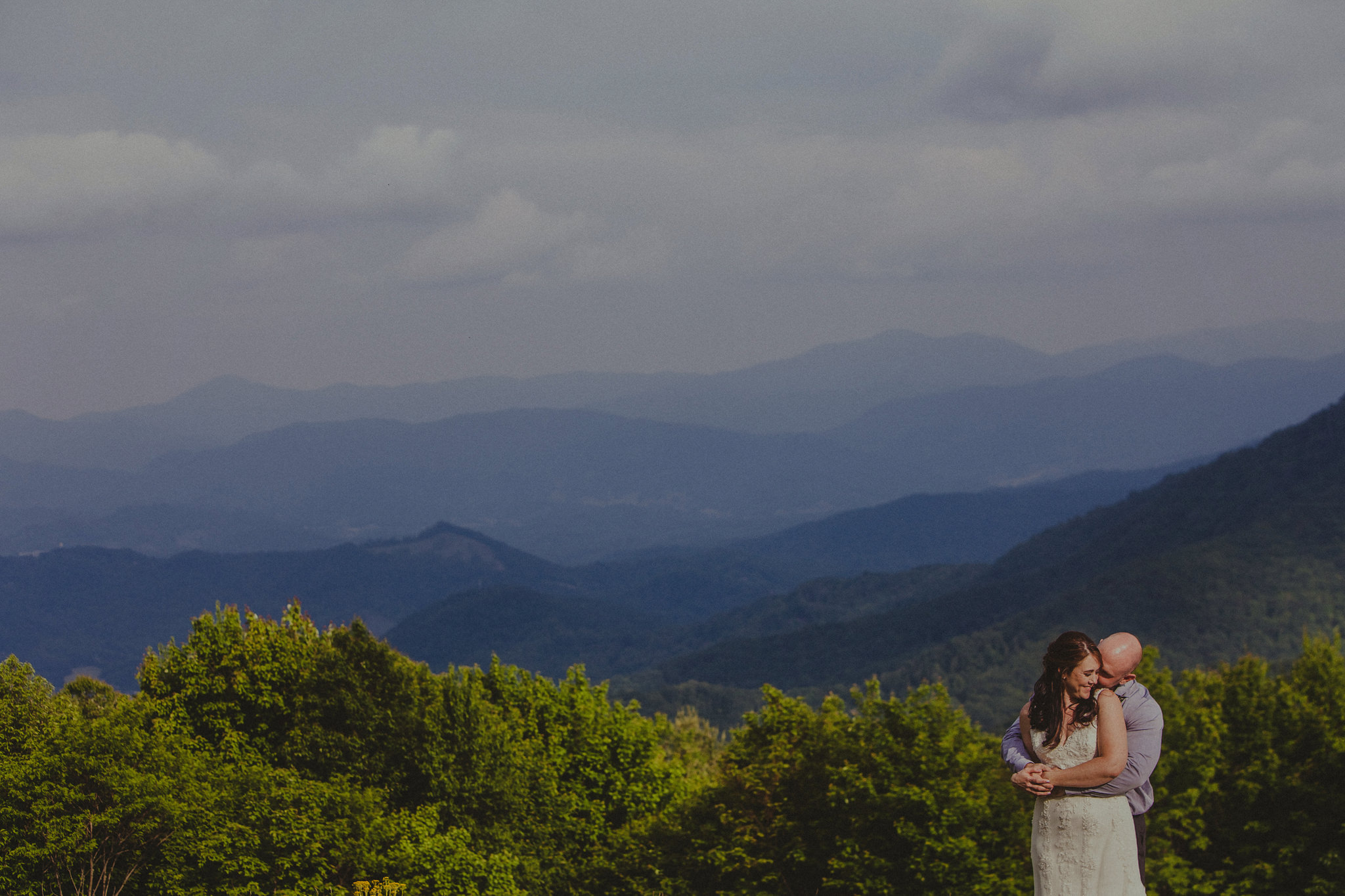 Newly weds Nicki & Brad snuggle close with a breathtaking view of the appalachian mountains on the blue ridge parkway.