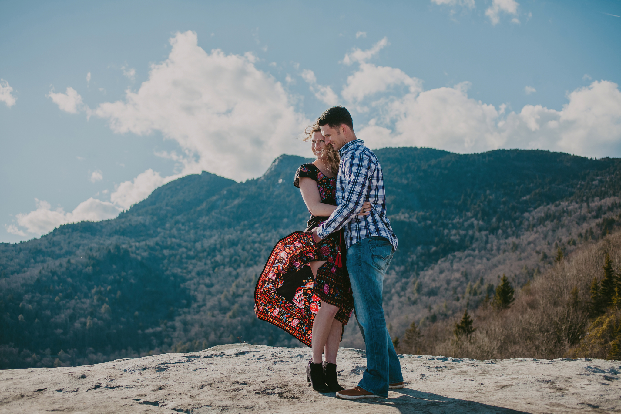 The wind blows bride's dress during their mountain engagement session on the blue ridge parkway photos by Mabyn Ludke Photography