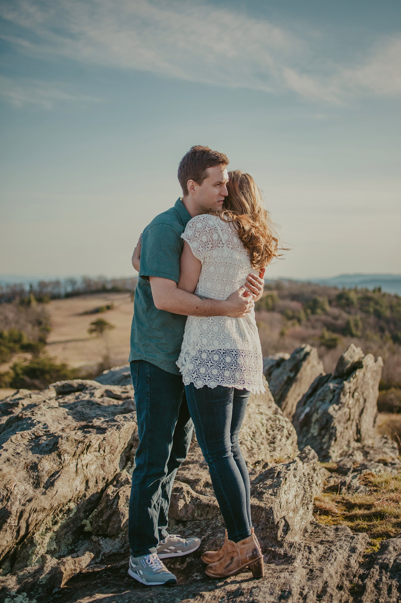 A couple hugs a top Doughton Park overlooking the Blue Ridge Parkway in NC. Mabyn Ludke Photography.