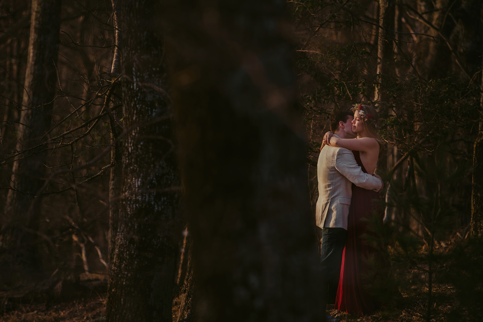 A beautiful couple embraces in the woods at Doughton Park near Sparta, NC. Photography by Mabyn.