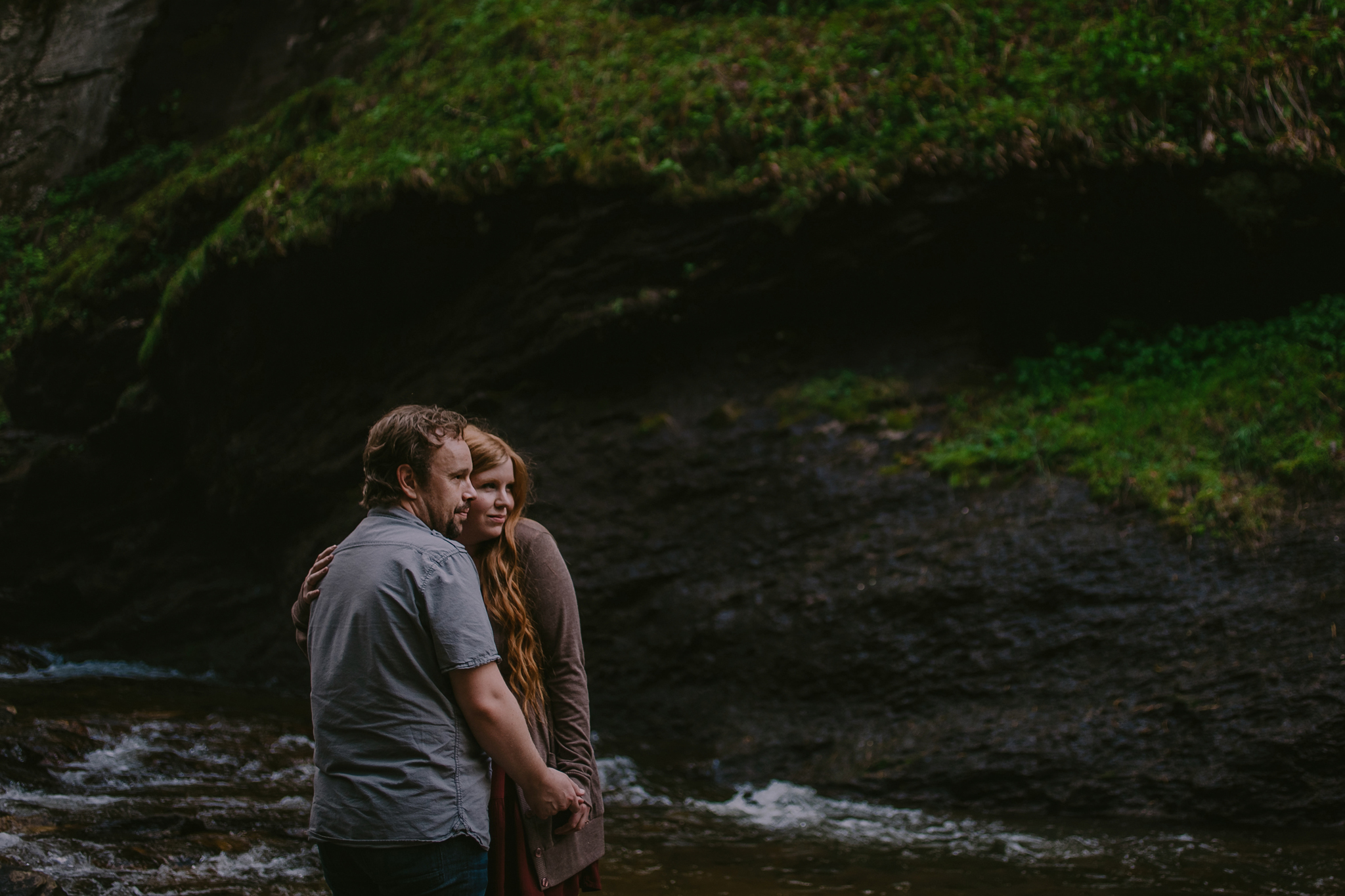 Couple snuggles in the river at Looking Glass Falls in Asheville, NC