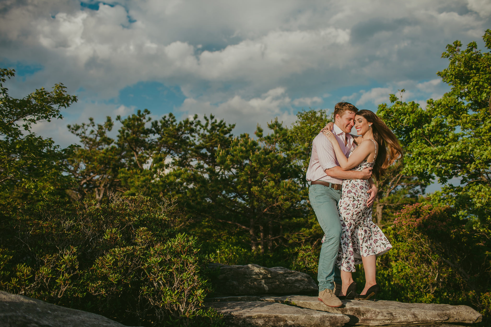 Couple basks in the sunlight on top of Hawksbill Mountain in the Appalachian mountains. Mabyn Ludke Photography
