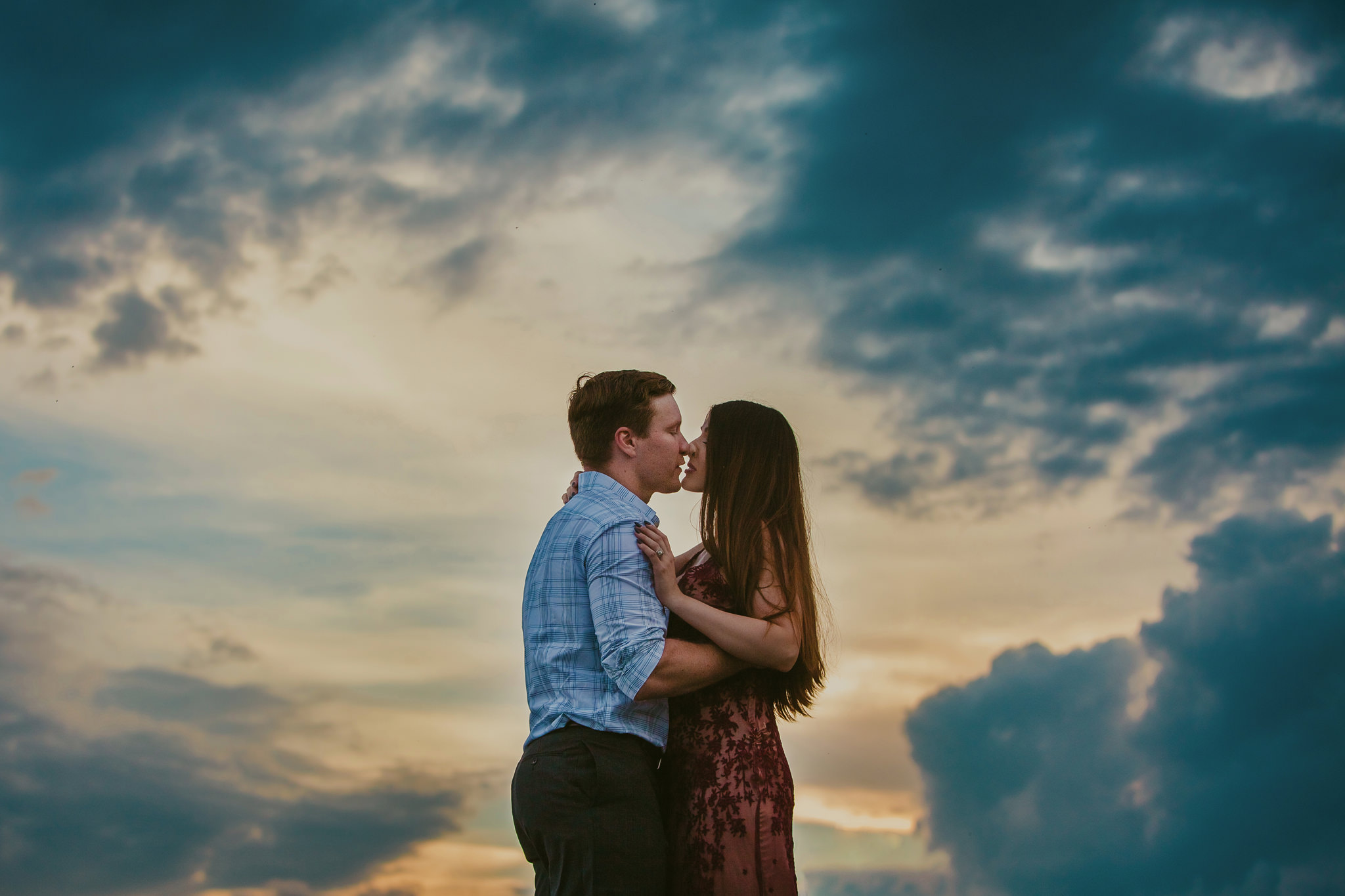 Blue and orange clouds surround a couple during their anniversary session at Hawksbill Mountain with Mabyn Ludke Photography.