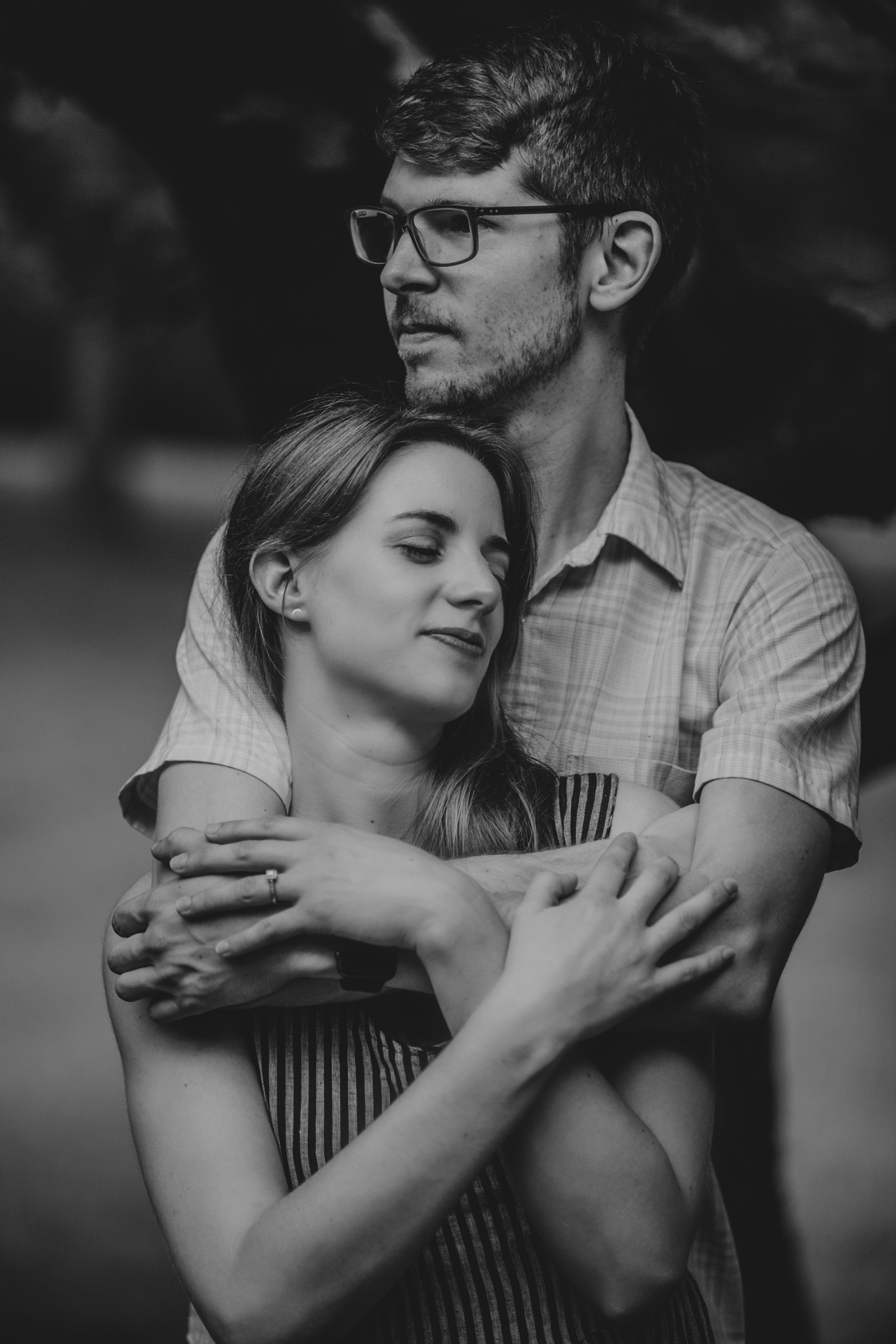 A black and white of a couple embracing in Greensboro, NC at the Timberlake Earth Sanctuary