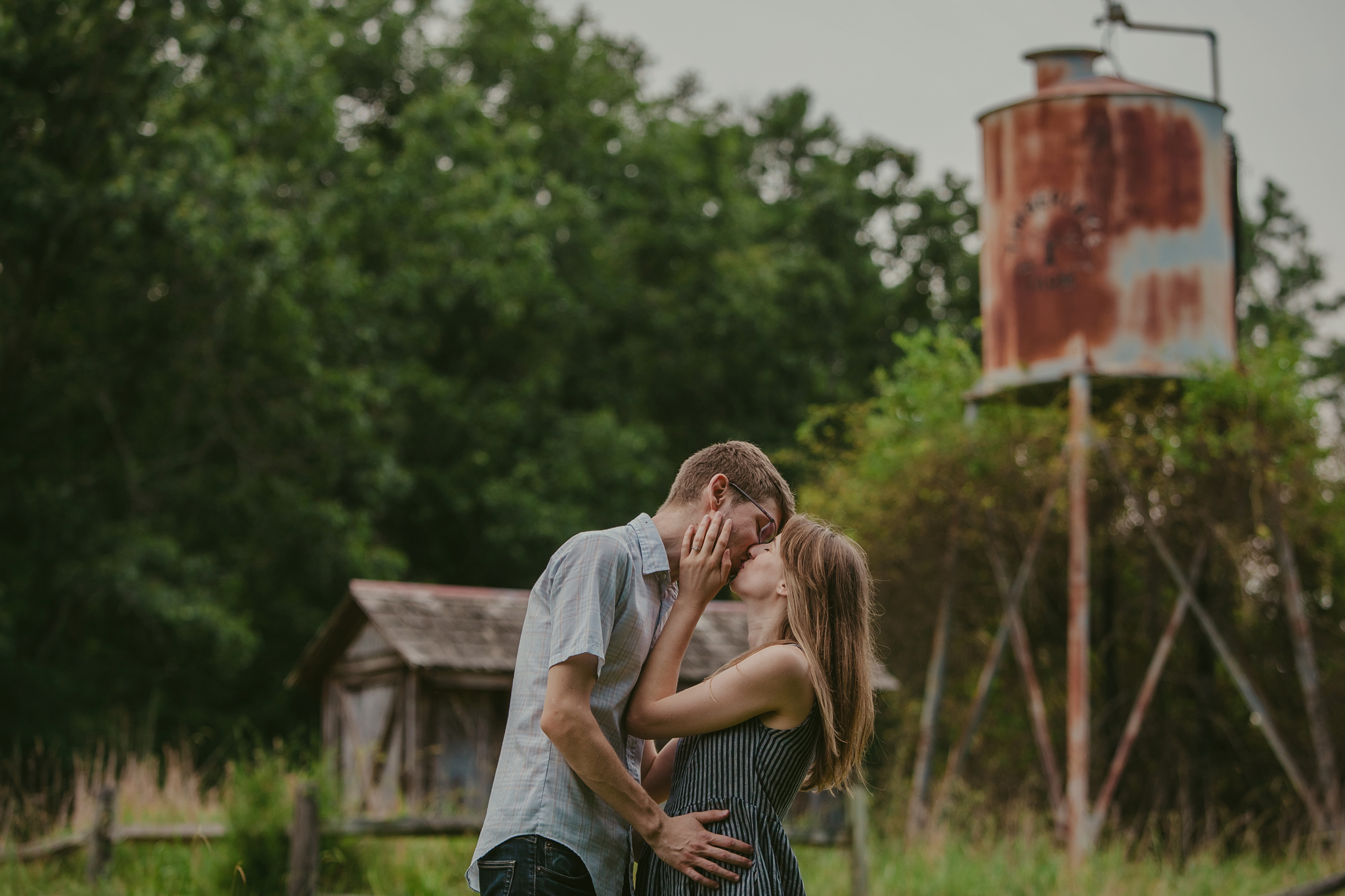 Couple kisses in front of the water tower at the Timberlake Earth Sanctuary in Greensboro, NC