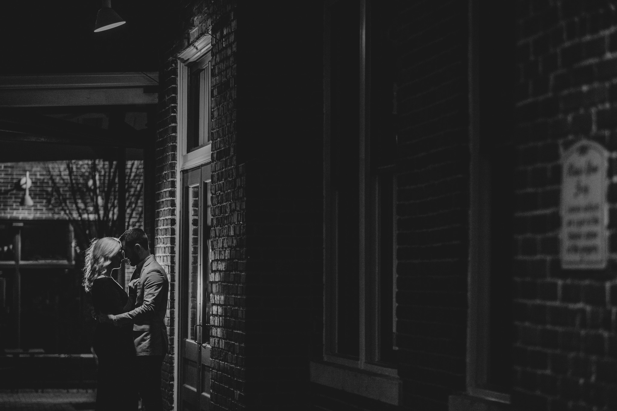 A nighttime shot of a couple embracing in downtown Raleigh