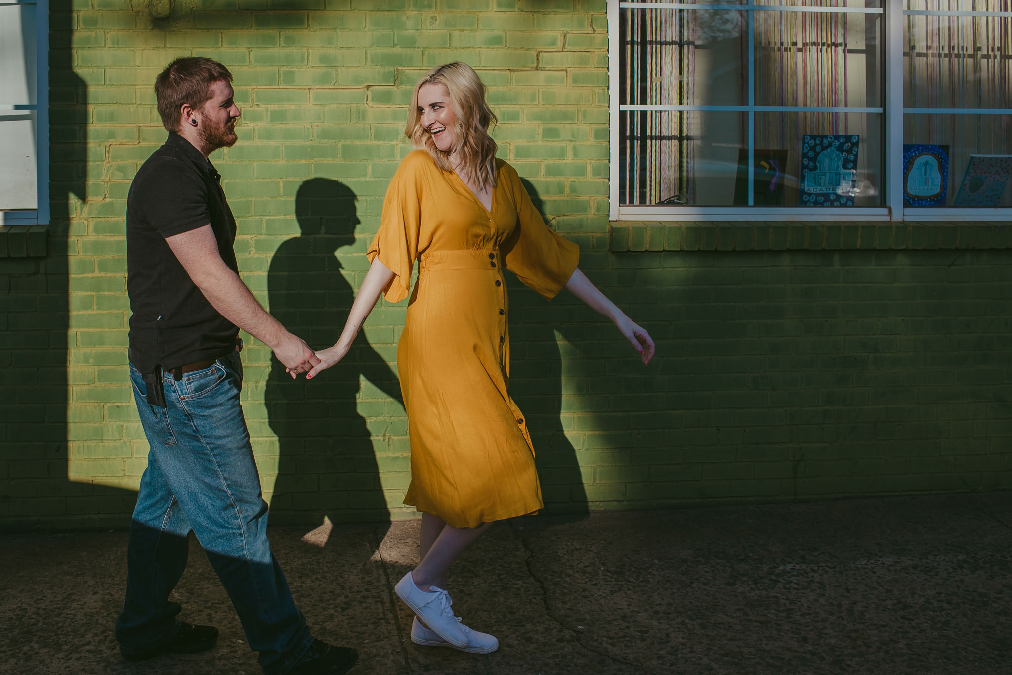 A lime green wall is a great contrast to a mustard yellow dress for this colorful maternity session on the streets of NoDa