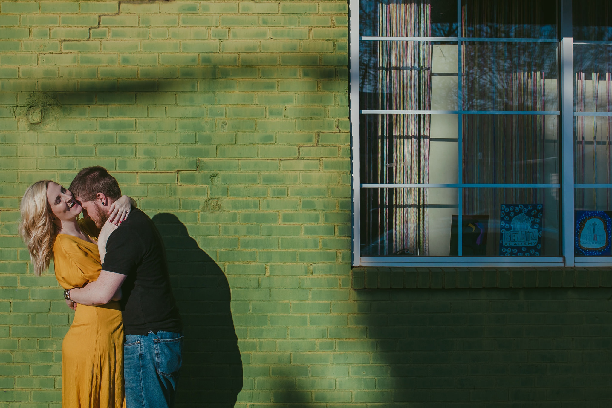 Couple kisses on the colorful streets of NoDa Charlotte for their Maternity Session