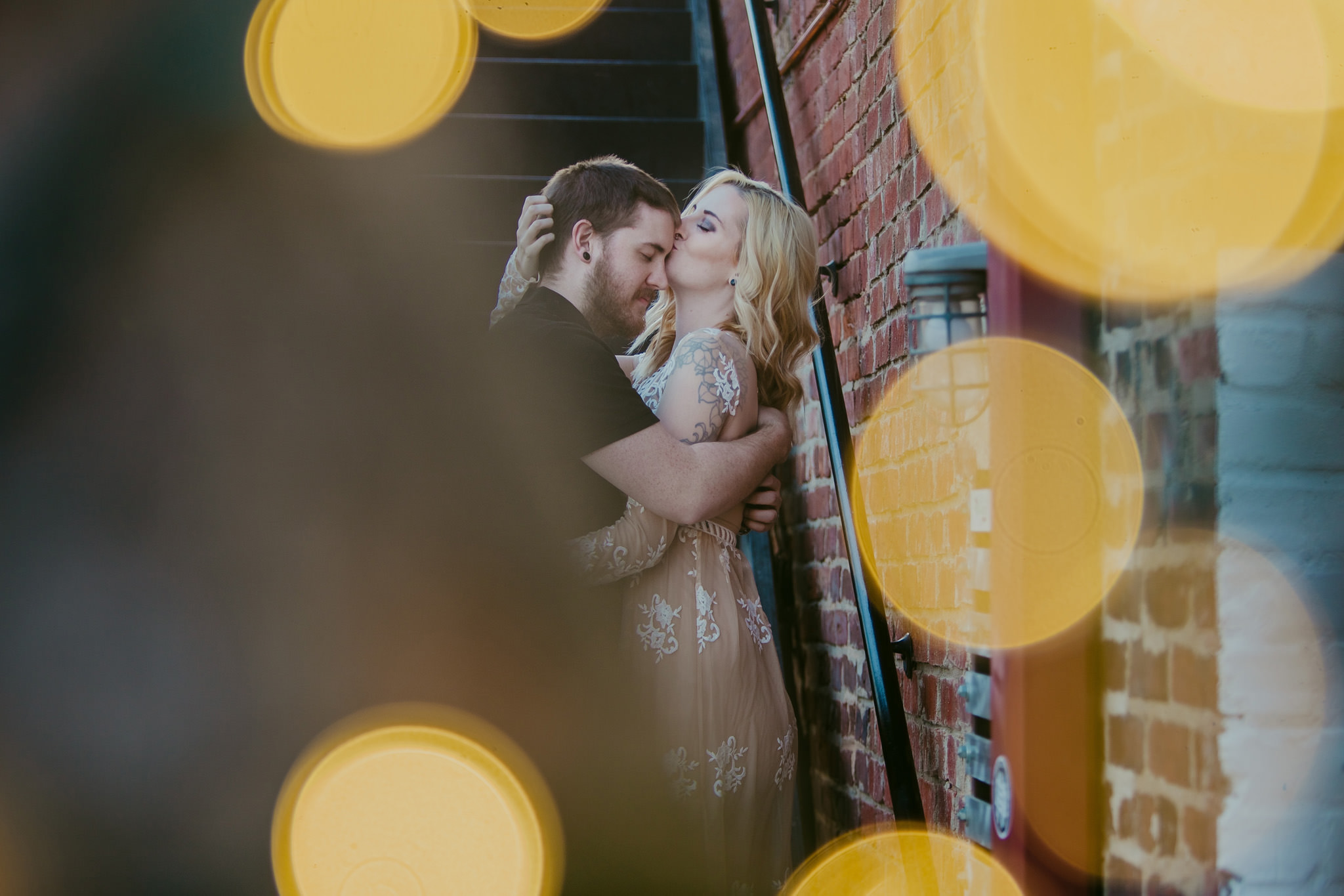Twinkle lights surround this sweet couple on the streets of NoDa for their maternity session in Charlotte, NC