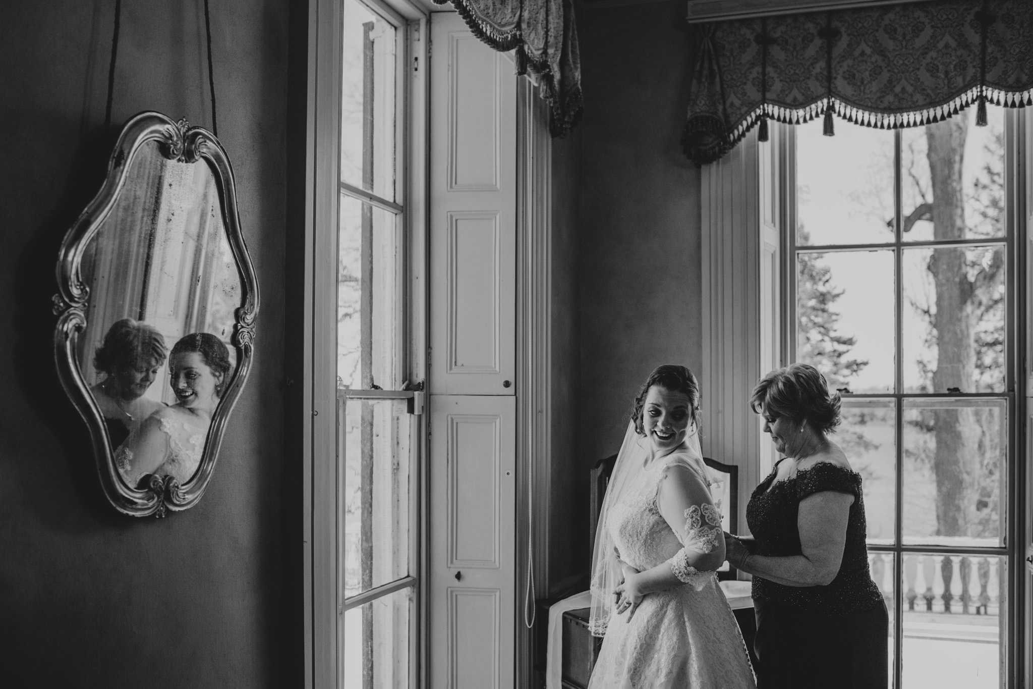 Lauren's mom helps her into her wedding dress at Glen Foerd on the Delaware near Philadelphia, PA
