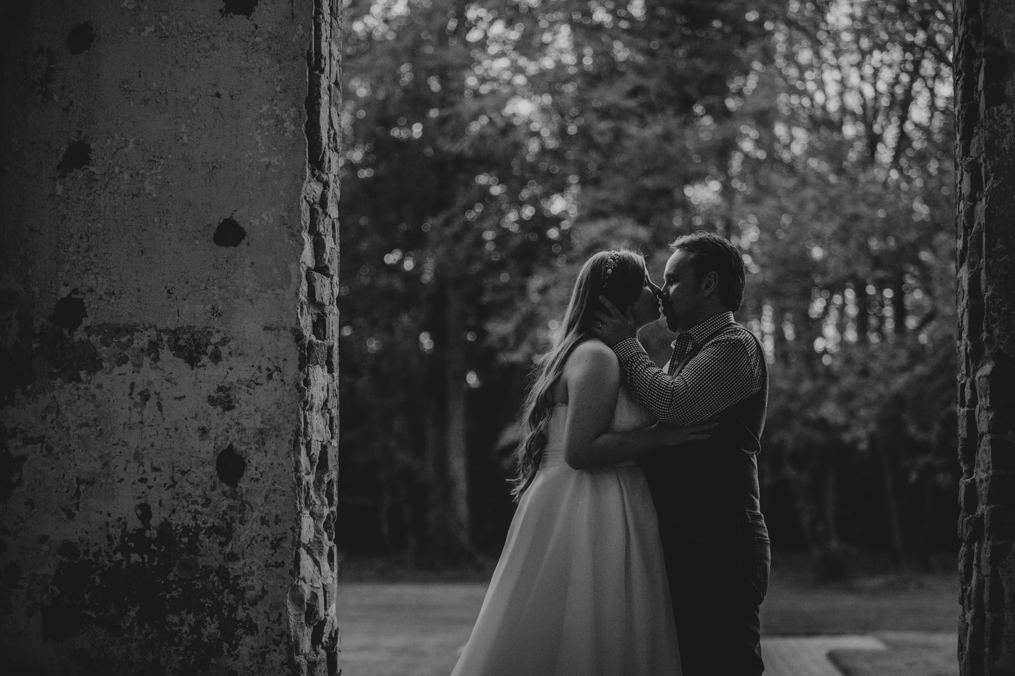 Couple snuggles in the doorway of the Providence Cotton Mill on their wedding day