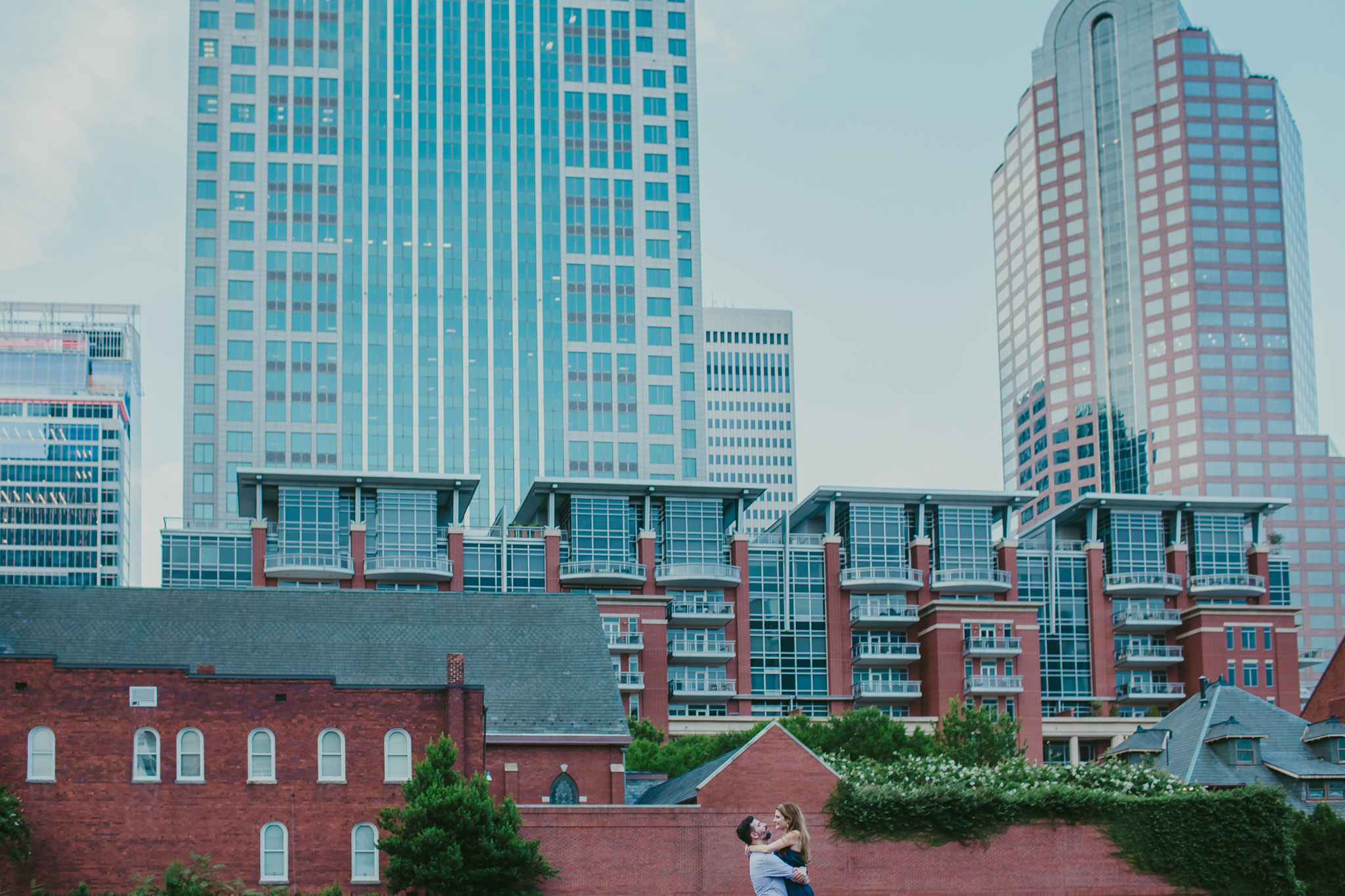 Couple hugs with the city scape of Uptown Charlotte in the background