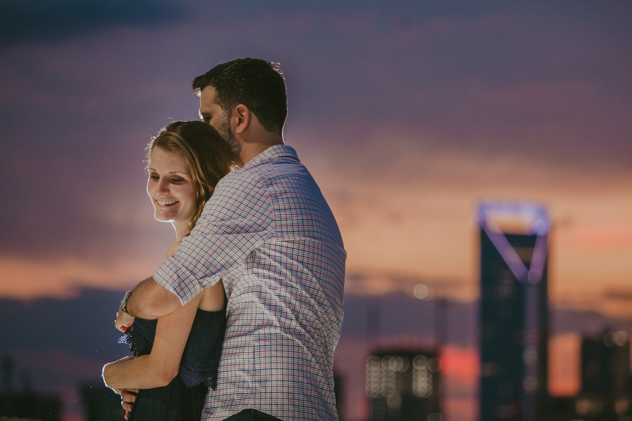 A sweet hug with the duke energy building in the background at this Charlotte, NC engagement session