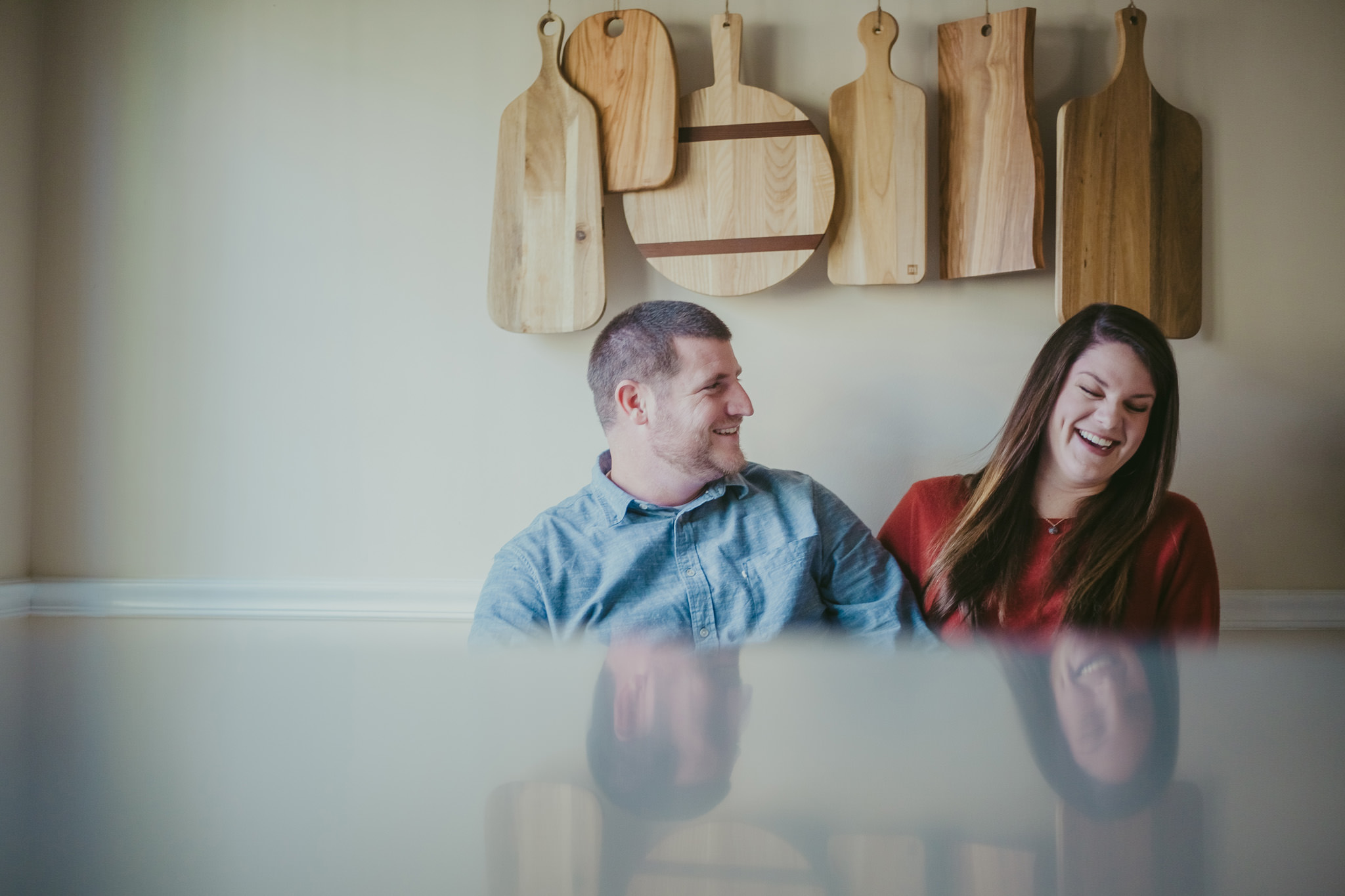 Couple laughs together at their home engagement session in Charlotte NC