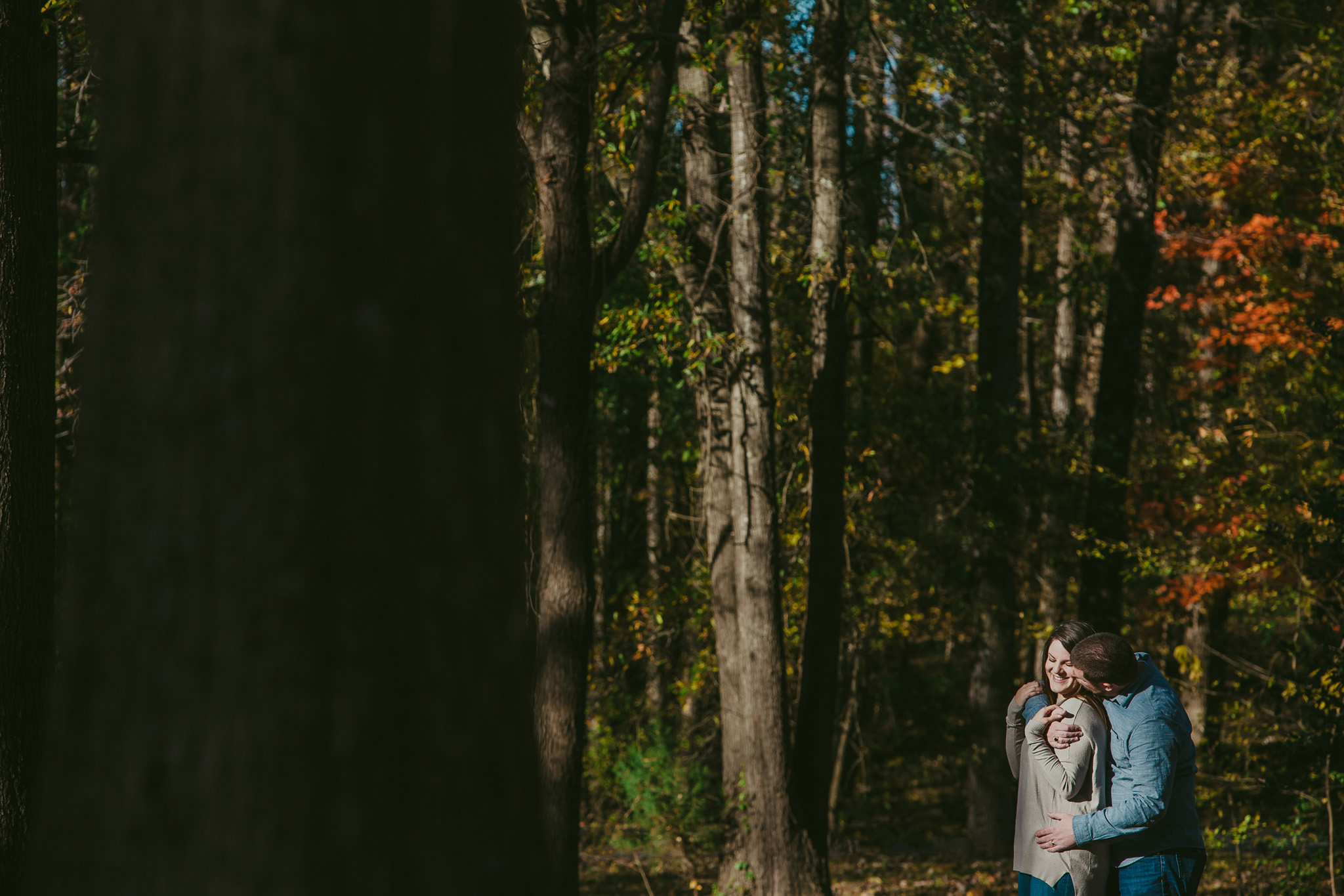 Lauren and Adam snuggle in their yard near Charlotte, NC at their engagement session