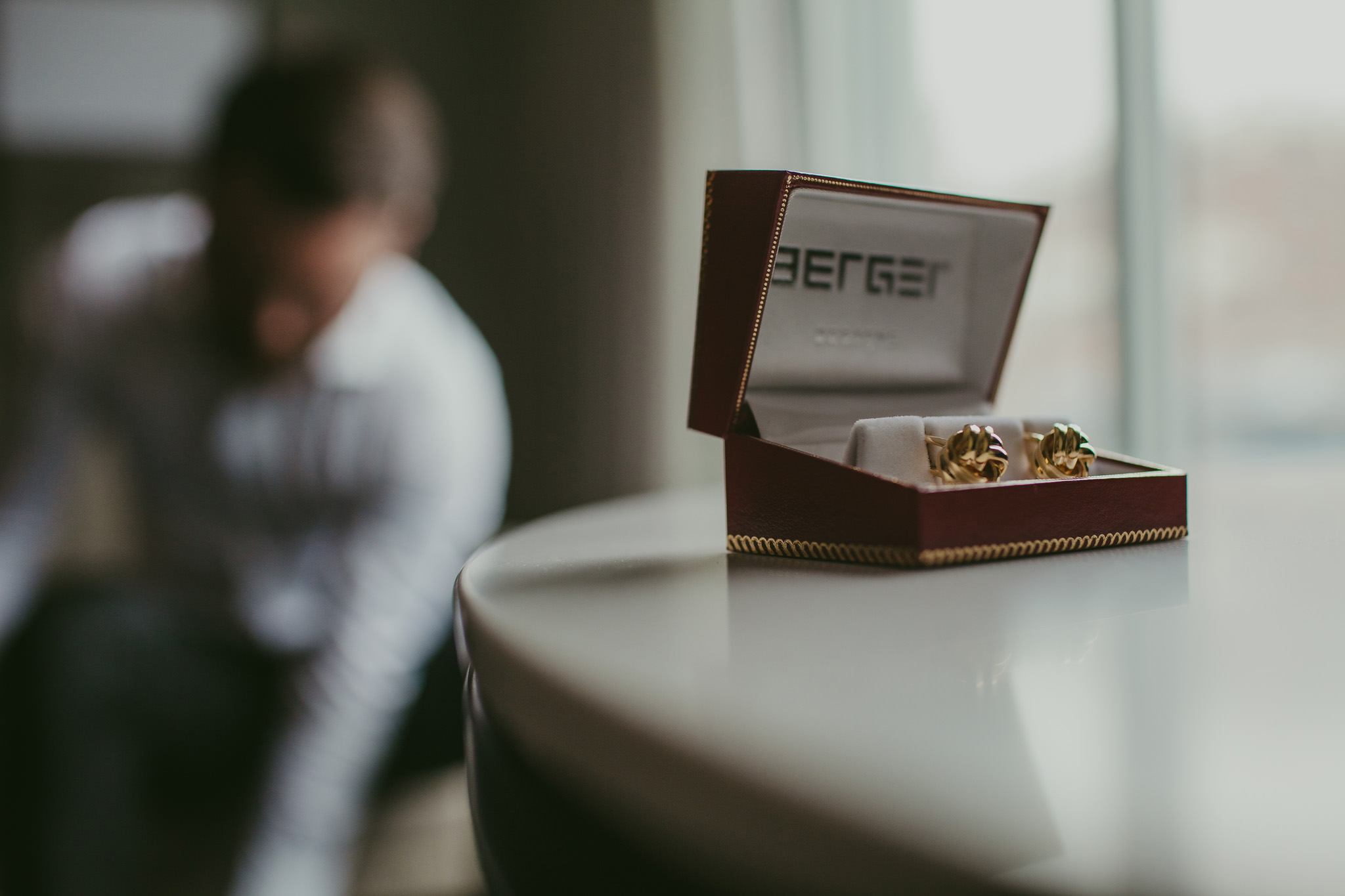 Groom's cufflinks as he gets ready in the background in Raleigh, NC