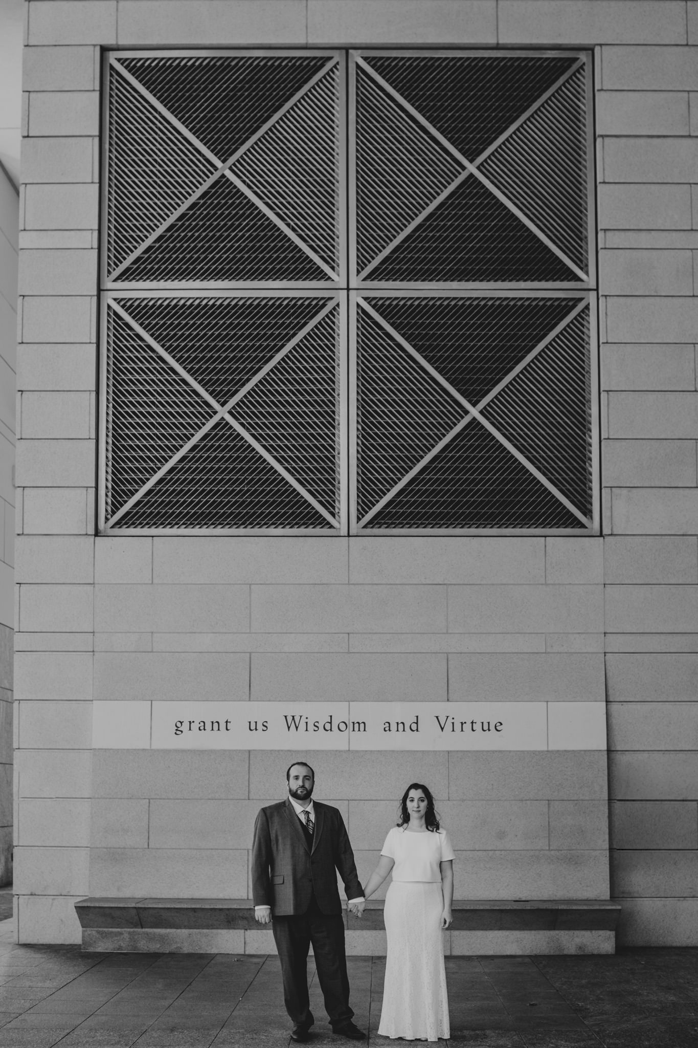 newlyweds pose in front of mecklenburg courthouse for their Uptown Charlotte elopement