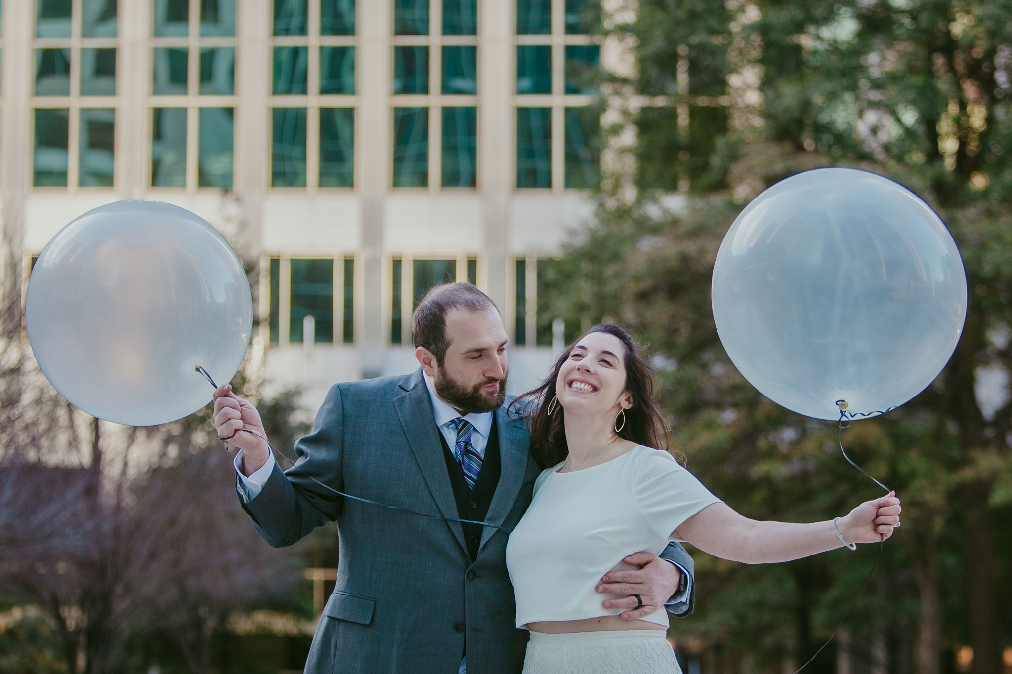 bride and groom laugh with bubble balloons in uptown Charlotte, NC