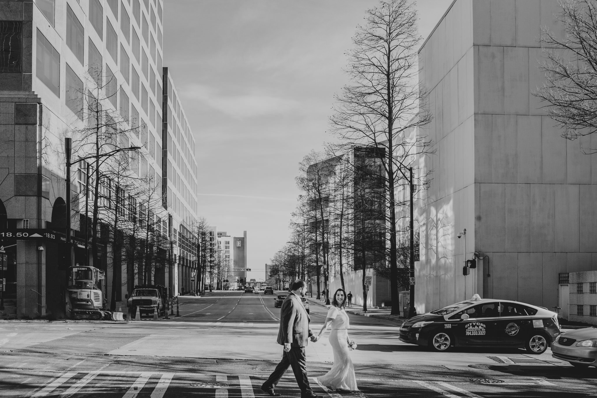 Bride and groom cross the street in uptown Charlotte, NC