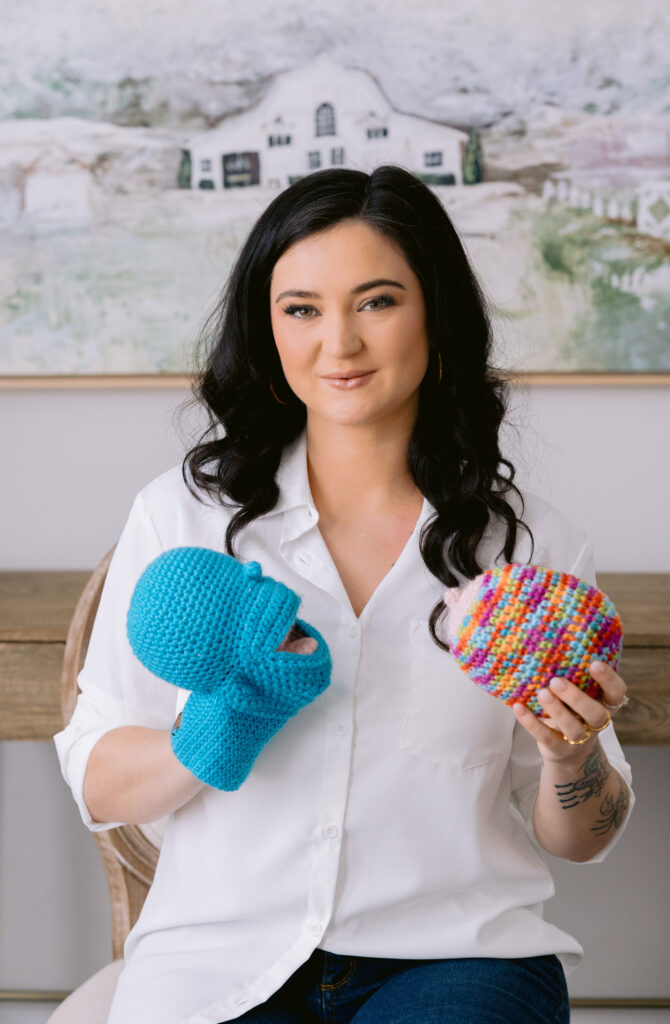 A woman holds up two colorful educational tools, perfect for adding warmth and style to personal branding headshots. What to wear for headshots in Charlotte NC