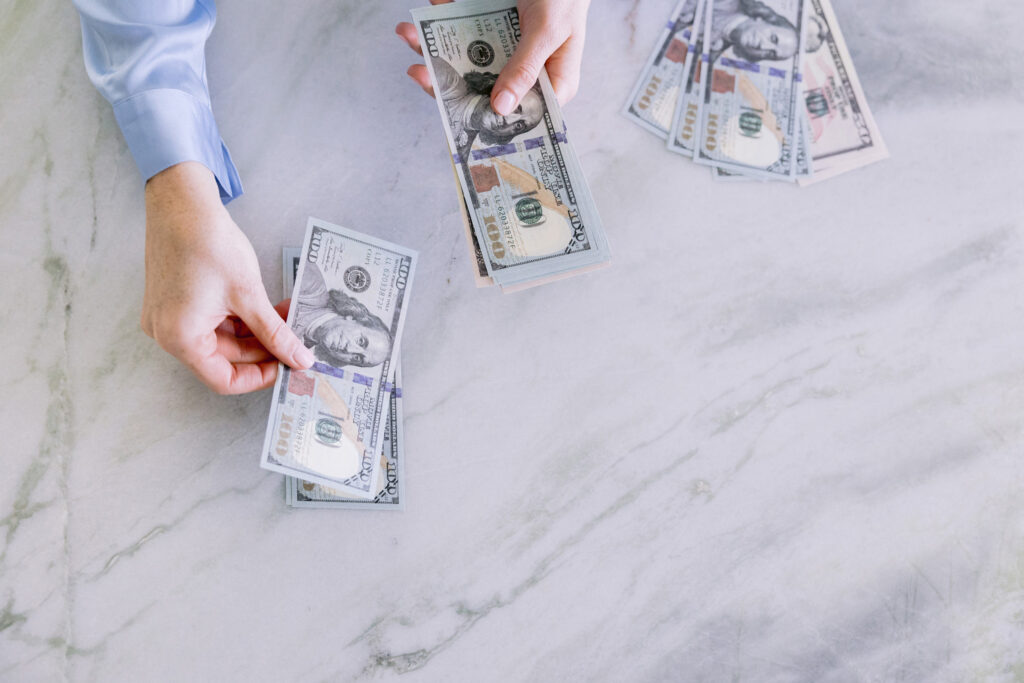  A person showcases money in their hands, captured during a personal brand photoshoot for a financial advisor by Mabyn Ludke Photography.