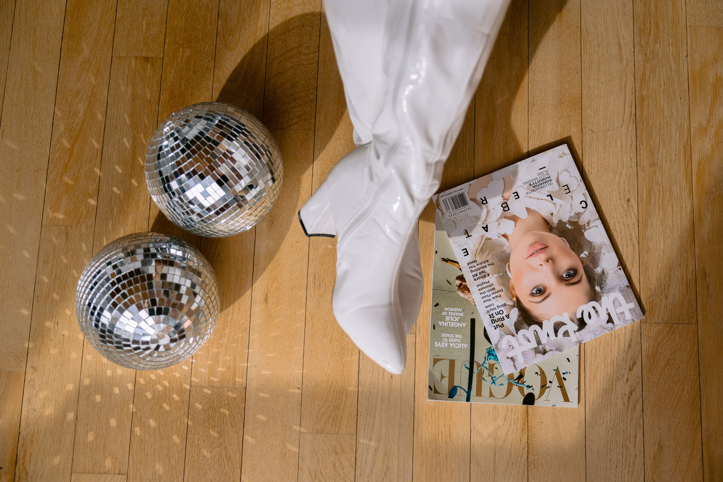  A woman's legs and fashionable shoes are positioned on the floor next to a magazine, highlighting personal branding.