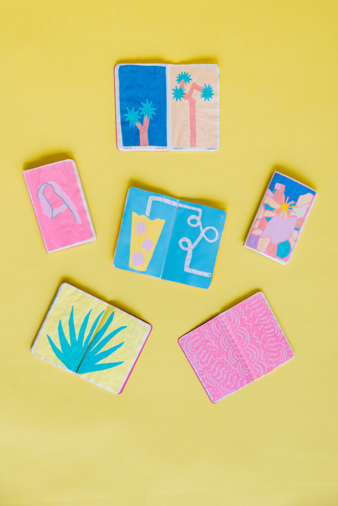 A lively collection of cards with palm tree motifs and artistic designs, highlighting Liz Brindley's creative flair. Photograph by Mabyn Ludke Photography