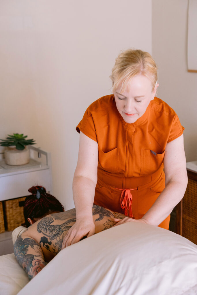 A woman enjoys a relaxing massage in a serene room, showcasing Lisa Cordia Holistic Therapies. Photo by Mabyn Ludke.